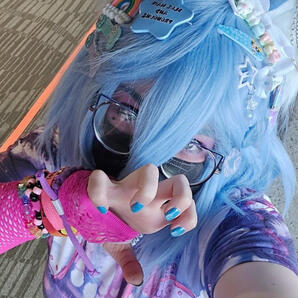 Zircon's face, smirking. She has pale skin, light blue hair, large wolf ears, purple eyes, and a pink collar with a bone-shaped tag with the letter Z on it. image by Lizapproved