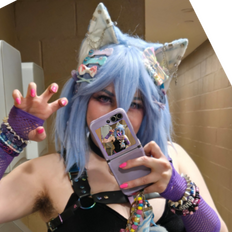 Zircon's face, smirking. She has pale skin, light blue hair, large wolf ears, purple eyes, and a pink collar with a bone-shaped tag with the letter Z on it. image by Lizapproved